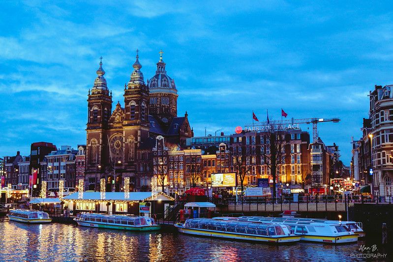 Basilica of St. Nicholas Church Amsterdam as seen from the water with boats docked in front.