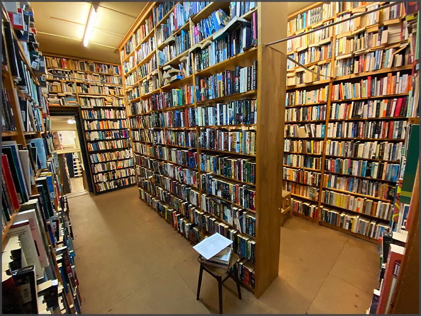 Books upon second hand books stacked in wooden shelves in The Book Exchange store.