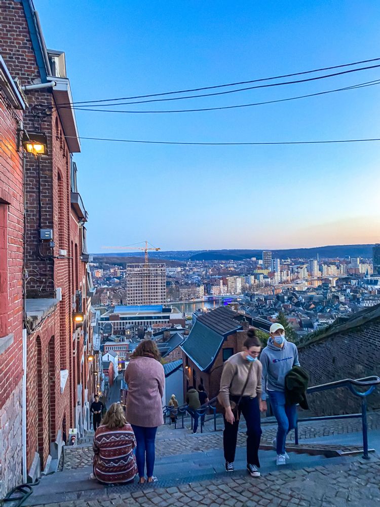 Young women walking and two resting on the steps of Montagne de Bueren, Liege, Belgium