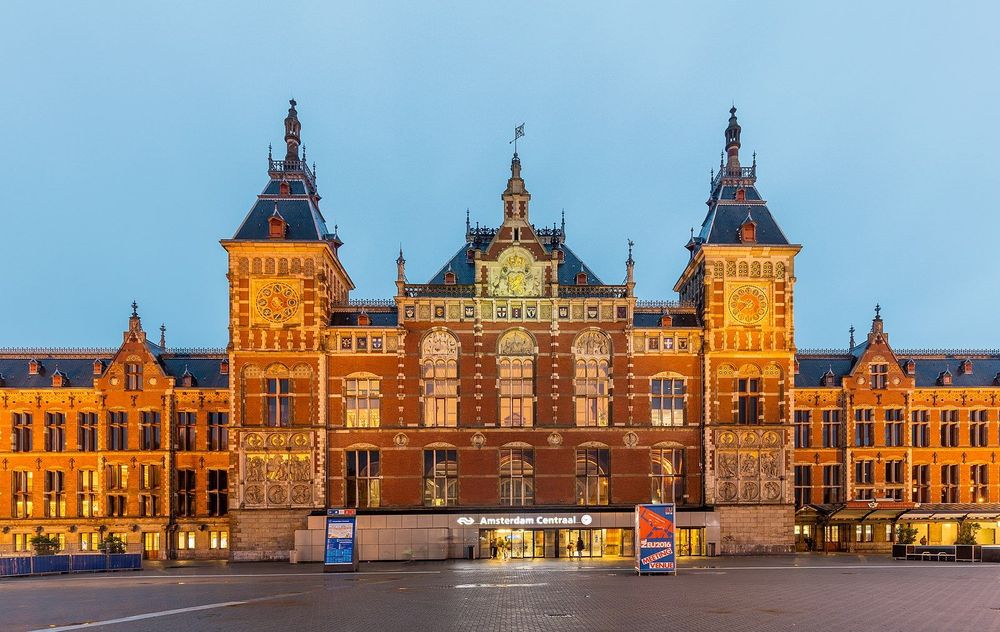 Amsterdam Centraal Station lit up in the evening.