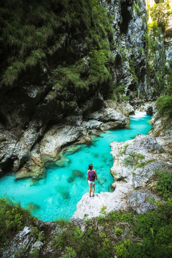 A person standing on the edge of a cliff at the Tolmin Gorge.