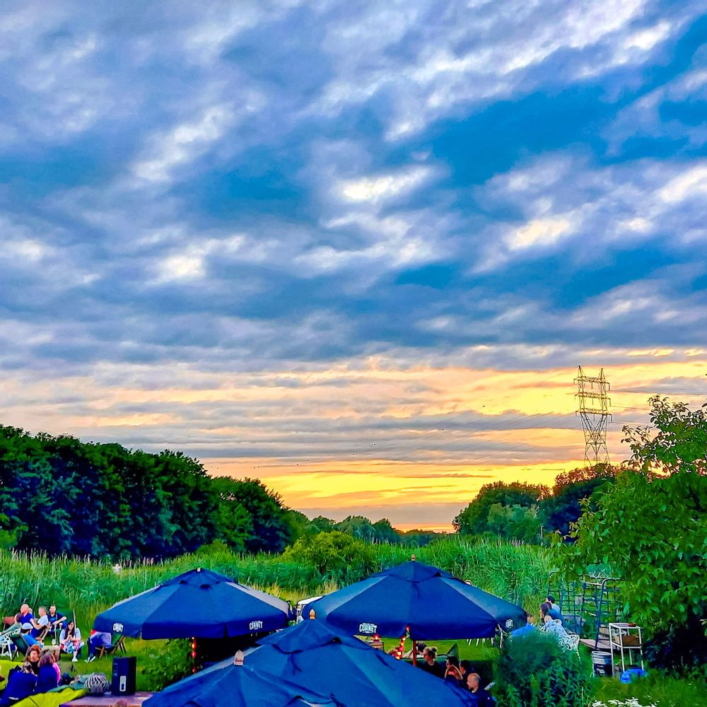 Sunset behind outdoor terrace eating area with umbrellas