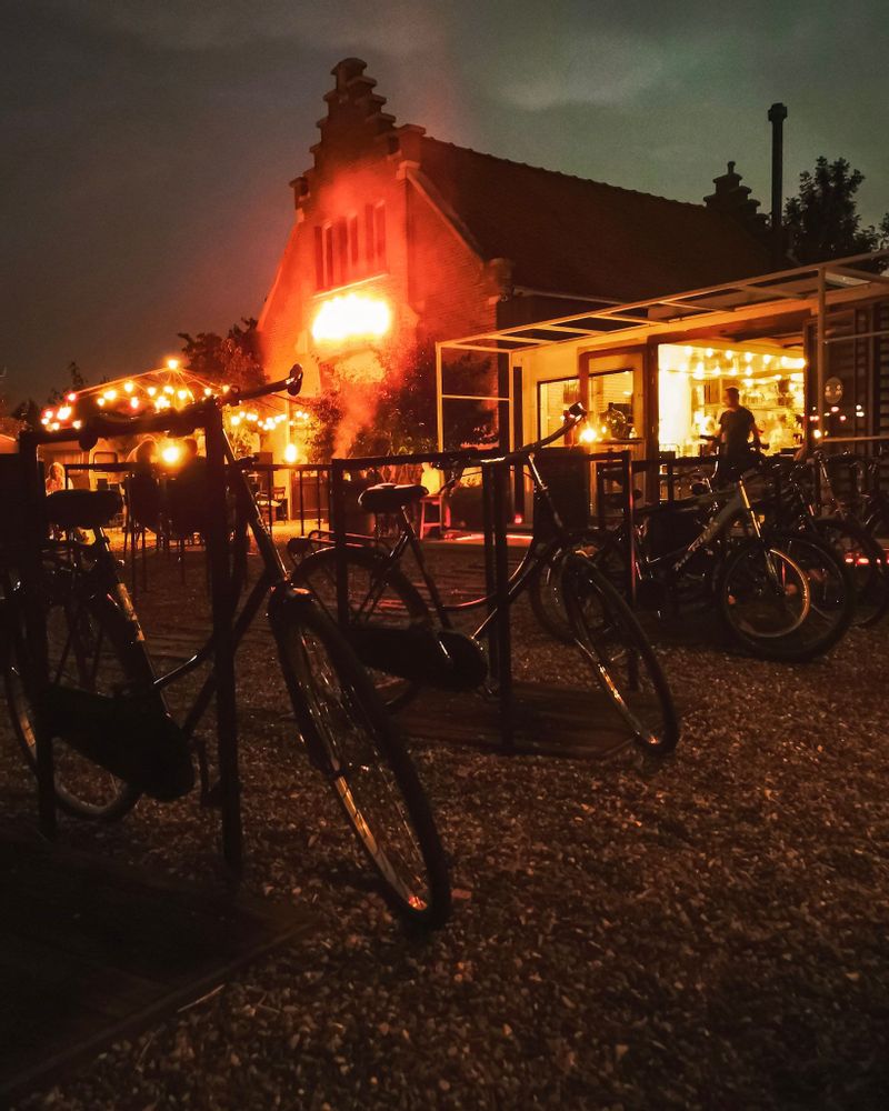 Night time outside by the bikes, background is lit up by fairy lights