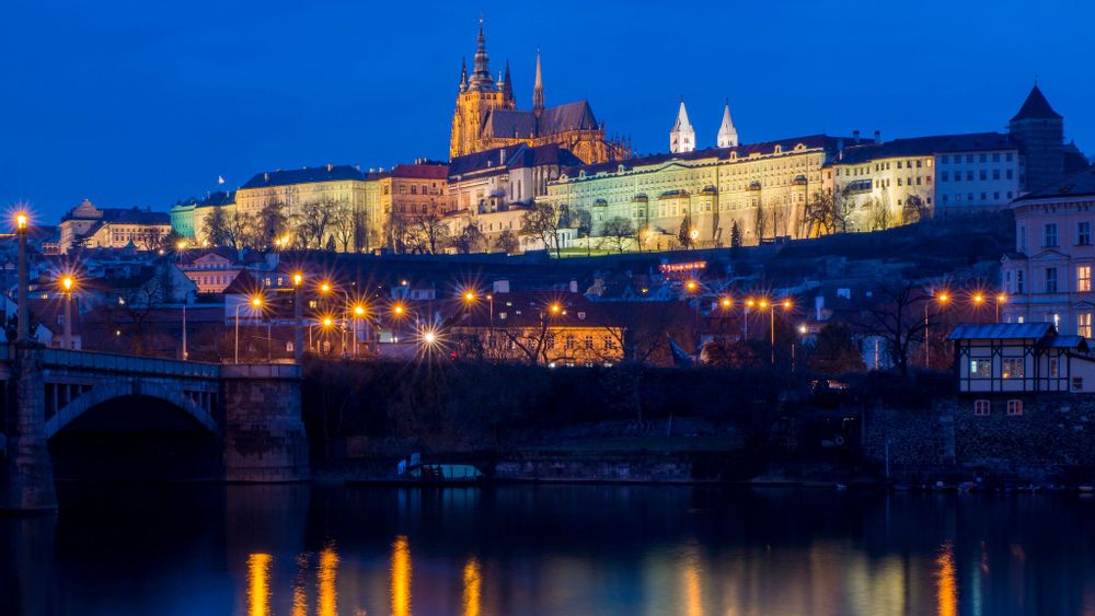 Street lights on the bridge alight across the river Vltava to Prague Castle, Prague