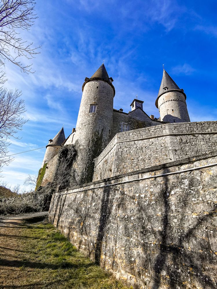 Grey medieval castle with 3 visible turrets in the day, Vêves Castle, Namur, Belgium
