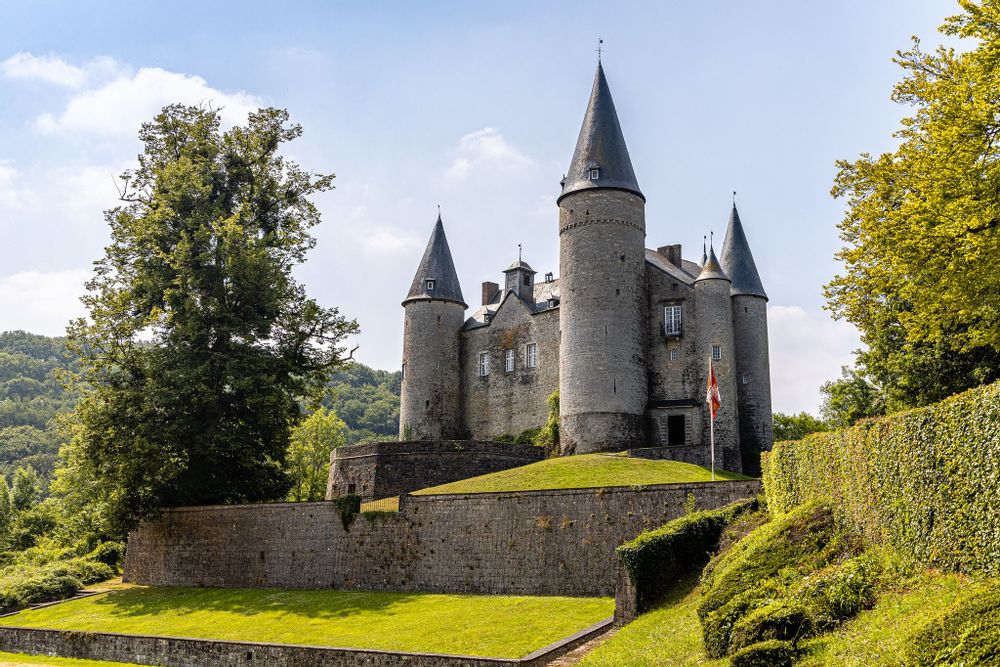 Medieval castle on a grassy bank with trees, Vêves Castle, Namur, Belgium