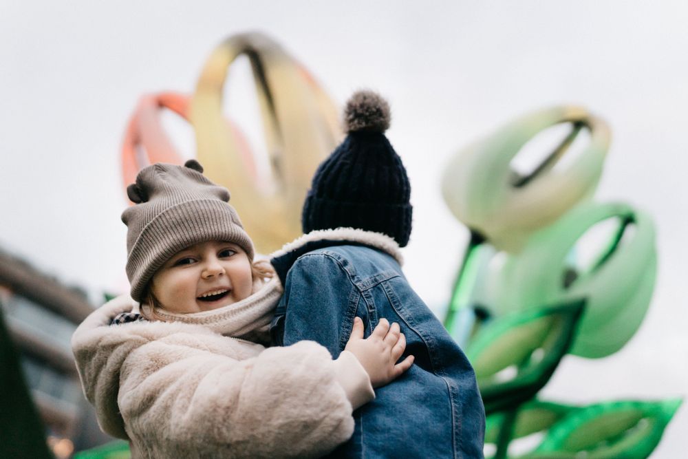 Toddler and family viewing a flower-like light art display at the Light ART festival, Knokke-Heist