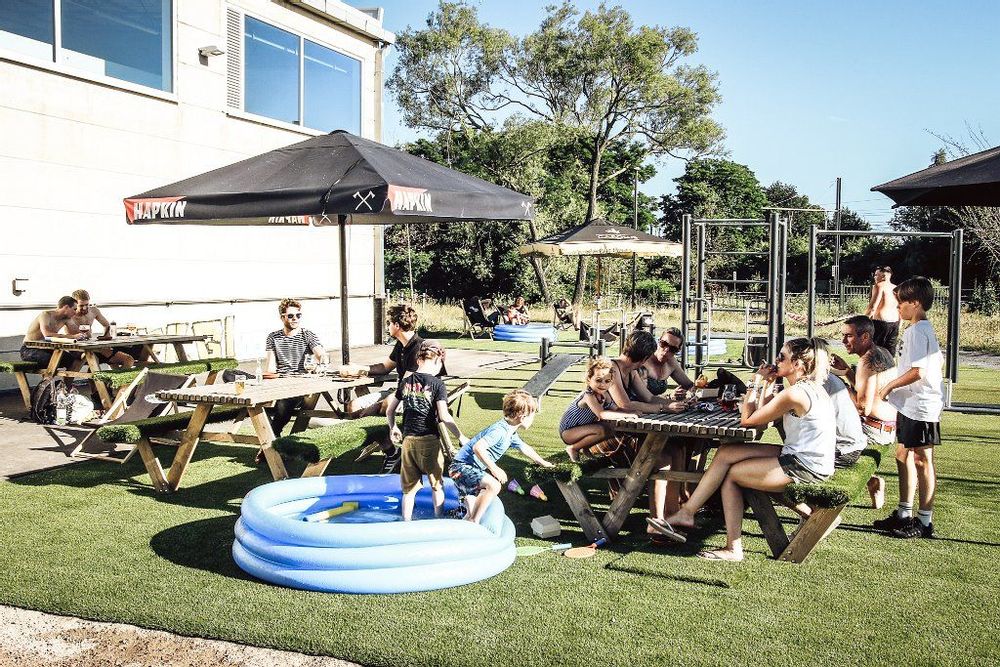 People outside at picnic tables and a kiddy pool