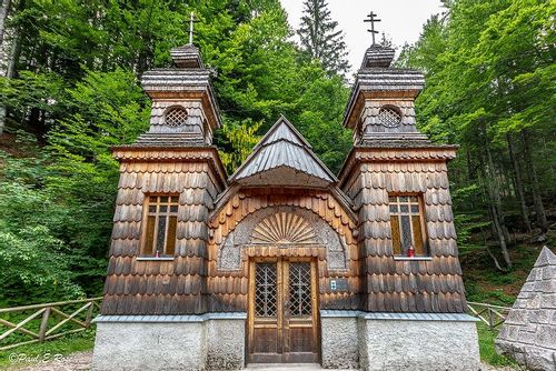 The exterior of the Russian Chapel on the Vršič Mountain Pass in the forest.