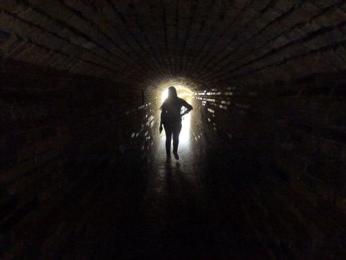Woman walking through a world war bunker tunnel at Atlantikwall, Ostend, Belgium