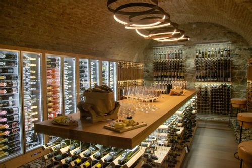 The interior wine cellar of Grajska Vinoteka with full wine case on display.