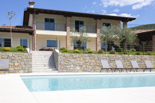 Kamp Brda in front of its pool with pool chairs.