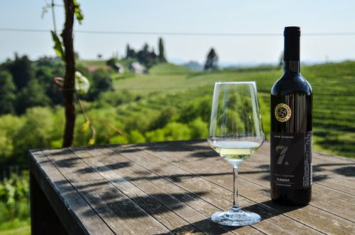 A bottle of wine and a glass overlooking the Puklavec Family Wines.