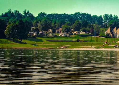The banks of Lake Butgenbach taken from the water, in the domain of VENNtastic beach.