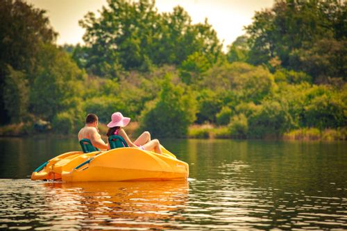 Two people in a yellow pedalo boat in Lake Butgenbach.
